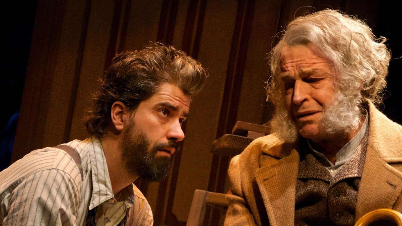 Two men, one older with gray hair, the other younger with a beard, engage in a serious conversation, reflecting on posterity.