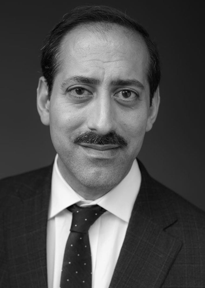 James Rana, a man with a mustache, wearing a suit and tie.