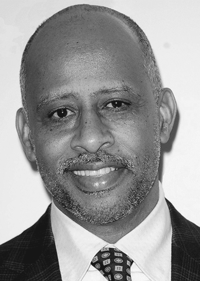 Ruben Santiago-Hudson smiling in a suit and tie.