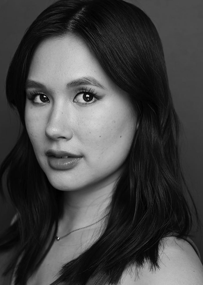 Black and white portrait of Camilla Shae, looking directly at the camera.