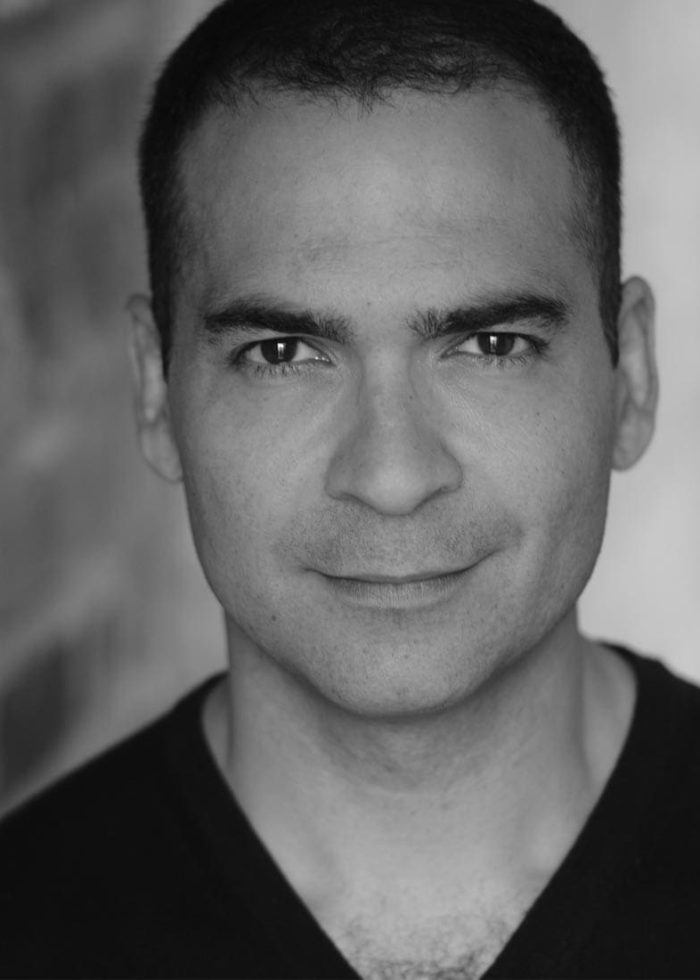 Close-up portrait of Teddy Cañez looking directly at the camera in black and white.