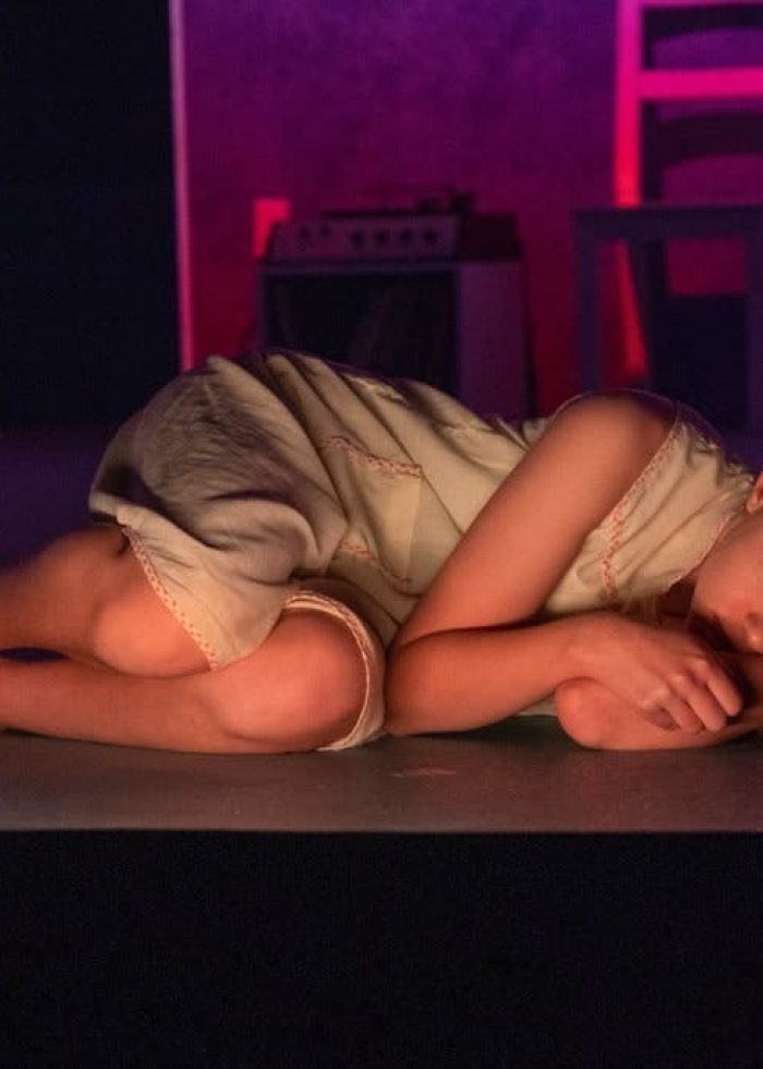 Actress lying on stage in a scene from "Anatomy of a Suicide.
